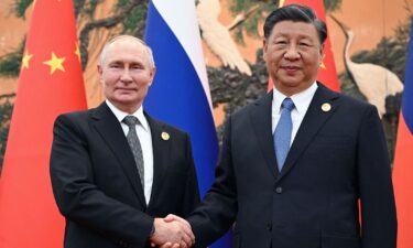 Russia's President Vladimir Putin and Chinese leader Xi Jinping shake hands during a meeting in Beijing on October 18