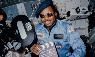 Astronaut Ronald E. McNair doubles as "director" for a movie being "produced" aboard the Earth-orbiting Space Shuttle Challenger in February 1984.