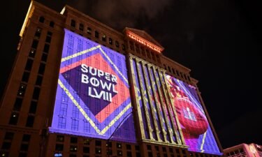 NFL Super Bowl LVIII football logos are projected on the side of Caesars Palace Las Vegas Hotel and Casino ahead of Sunday's game.