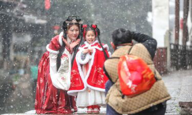 Tourists wearing Hanfu enjoy the snow in Xinshi Ancient Town in the Chinese city of Huzhou.