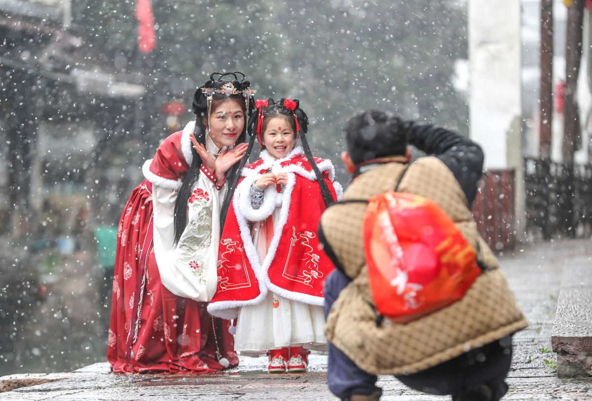 <i>CFOTO/Future Publishing/Getty Images</i><br/>Tourists wearing Hanfu enjoy the snow in Xinshi Ancient Town in the Chinese city of Huzhou.