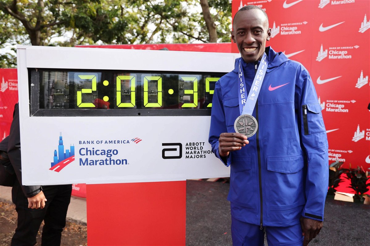 <i>Michael Reaves/Getty Images</i><br/>Kiptum stands next to a timer displaying his marathon world record in Chicago.