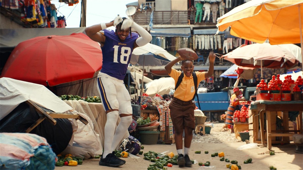 <i>NFL</i><br/>Minnesota Vikings wide receiver Justin Jefferson dances with the commercial's young star in the streets of Accra.
