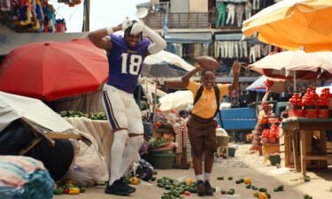 Minnesota Vikings wide receiver Justin Jefferson dances with the commercial's young star in the streets of Accra.