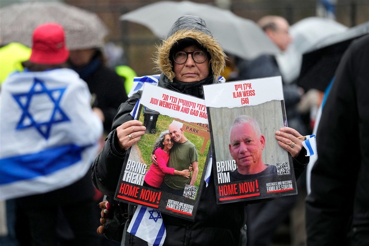 <i>Martin Meissner/AP</i><br/>A woman holds images of hostages at The Hague on Wednesday