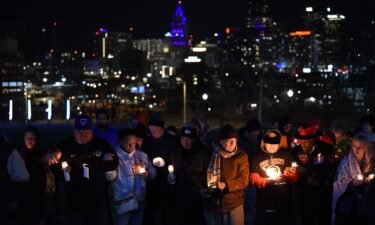 People hold candles during a vigil in Kansas City on Thursday.