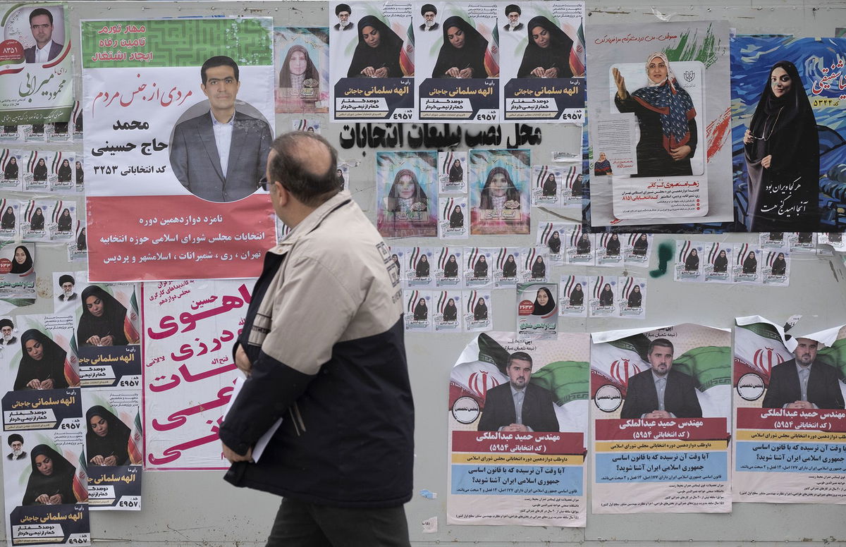 <i>Hossein Beris/Middle East Images/AFP/Getty Images via CNN Newsource</i><br/>Pedestrians pass by a poster featuring Ayatollah Khomeini