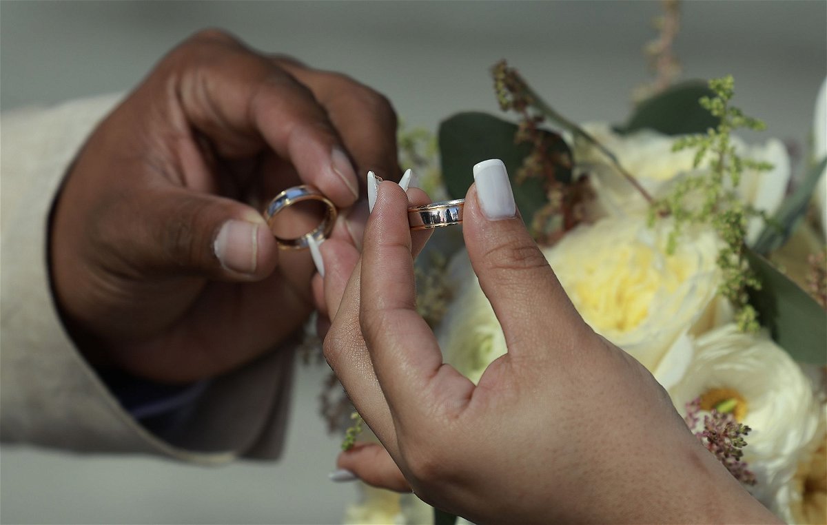 <i>Joe Raedle/Getty Images via CNN Newsource</i><br/>A couple exchanges rings during a Valentine's Day wedding ceremony on the steps of the Miami-Dade County Courthouse on February 14 in Miami