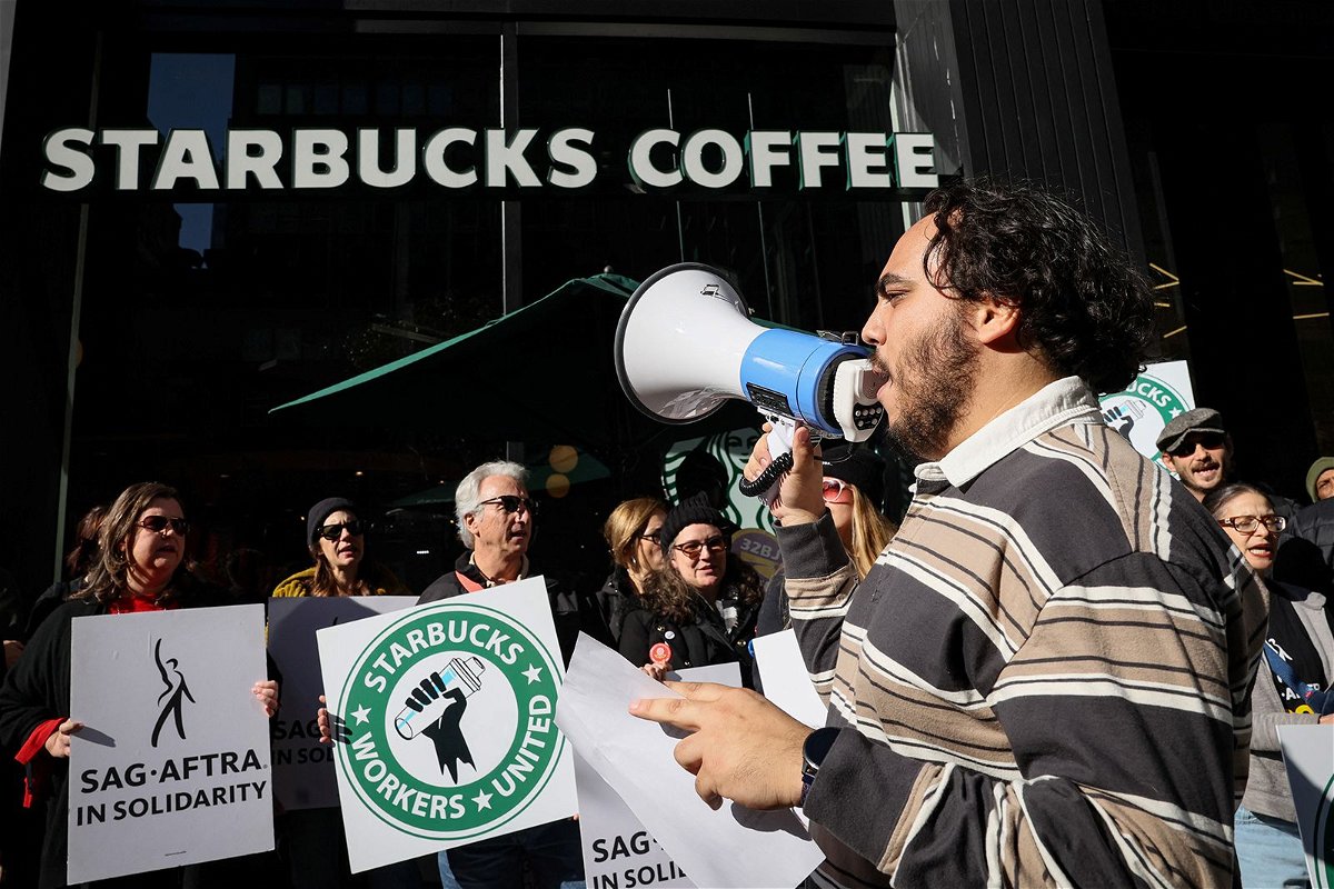 <i>Brendan McDermid/Reuters via CNN Newsource</i><br/>Members of the Starbucks Workers Union and other labor organization picket and hold a rally outside a company owned Starbucks store in New York City