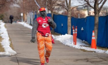 The Kansas City fan known as ChiefsAholic walks in January 2022 toward Empower Field at Mile High in Denver.