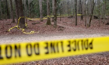Police tape drapes the crime scene on a trail behind Lake Herrick at the University of Georgia in Athens.