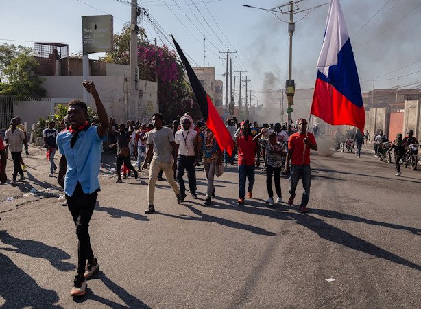 People carrying Haitian flags march during a demonstration demanding the resignation of Haitian Prime Minister Ariel Henry in Haiti on March 7, 2024.