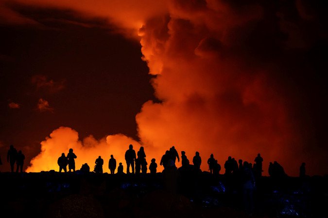 Spectators watch plumes of smoke from volcanic activity between Hagafell and Stóri-Skógfell, Iceland, on Saturday.