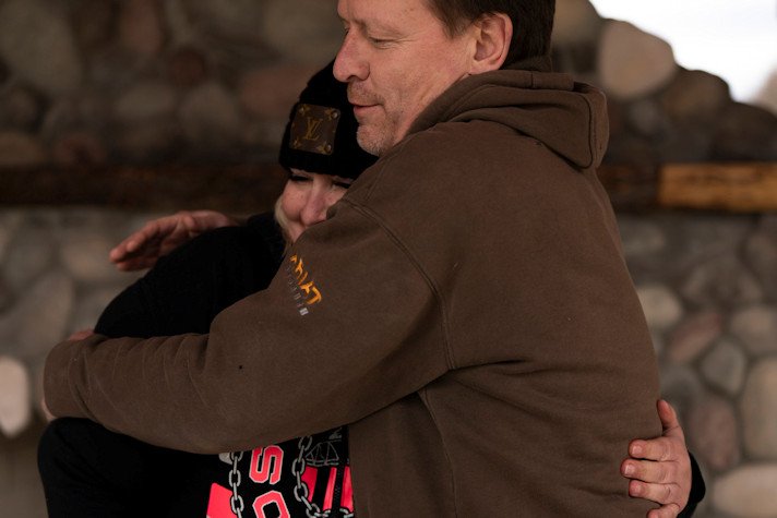 Jessica Pszonka hugs Dayn Brunner after they spoke during an interview while visiting the memorial for Oso landslide on Saturday, Feb. 17, 2024, in Oso, Wash. Dayn Brunner lost his sister Summer Raffo in the slide. Jessica Pszonka lost her sister Katie, two nephews, and three other family members. 
