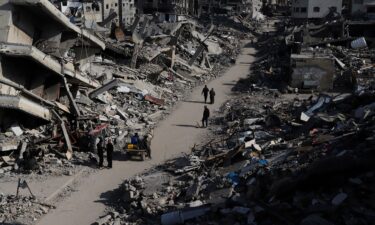 Palestinians walk through the destruction from the Israeli offensive in the Jabaliya refugee camp in the Gaza Strip on February 29.