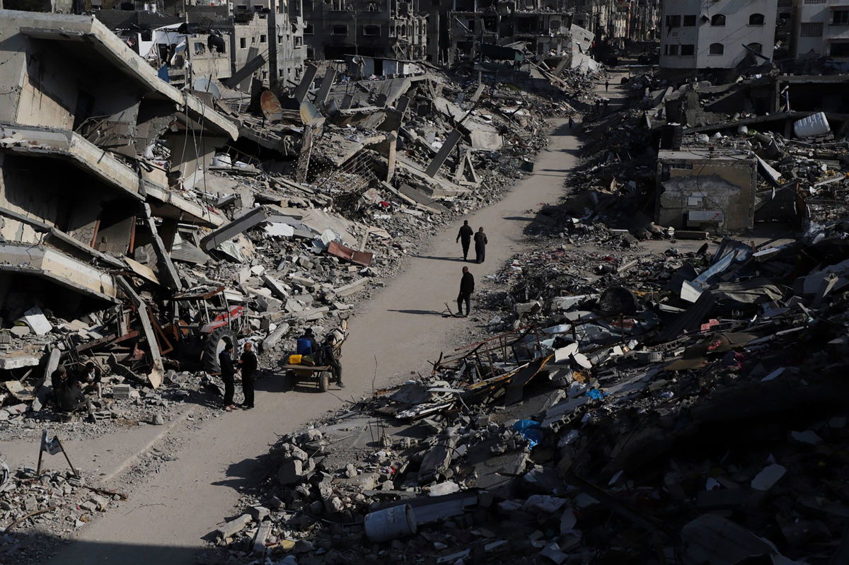 <i>Mahmoud Essa/AP via CNN Newsource</i><br/>Palestinians walk through the destruction from the Israeli offensive in the Jabaliya refugee camp in the Gaza Strip on February 29.