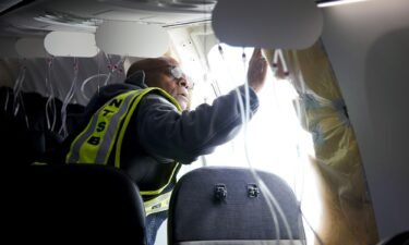 An NTSB Investigator examines the fuselage plug area of the Alaska Airlines plane after its January 5 flight.