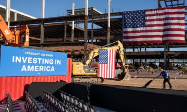 A woman vacuums the stage walkway prior to a speech from President Joe Biden at Intel Ocotillo Campus on March 20 in Chandler