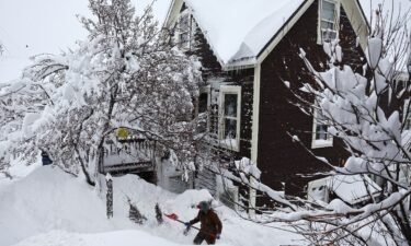 A worker digs out snow from a home north of Lake Tahoe during a powerful multiple day winter storm in the Sierra Nevada on March 02