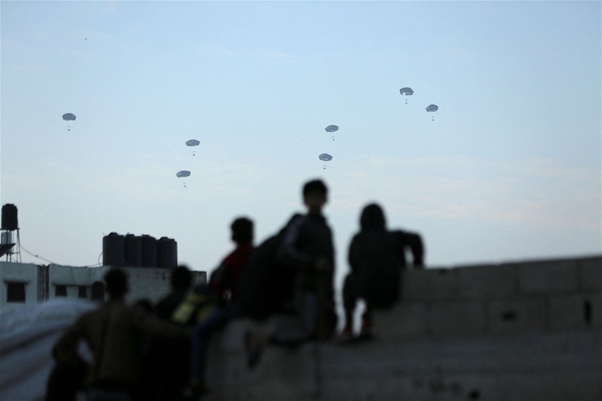 <i>Kosay Al Nemer/Reuters via CNN Newsource</i><br/>Palestinians watch as the US military air drops aid over Gaza on March 2.