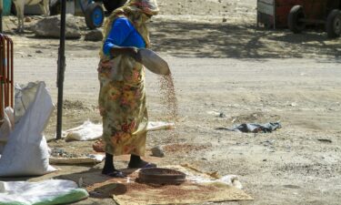 A woman sorts grains at a market in Gedaref