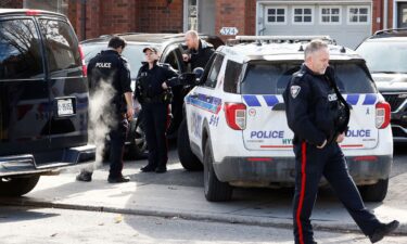 Ottawa Police Service officers surround a home after four children and two adults were found dead in the Ottawa suburb of Canada.