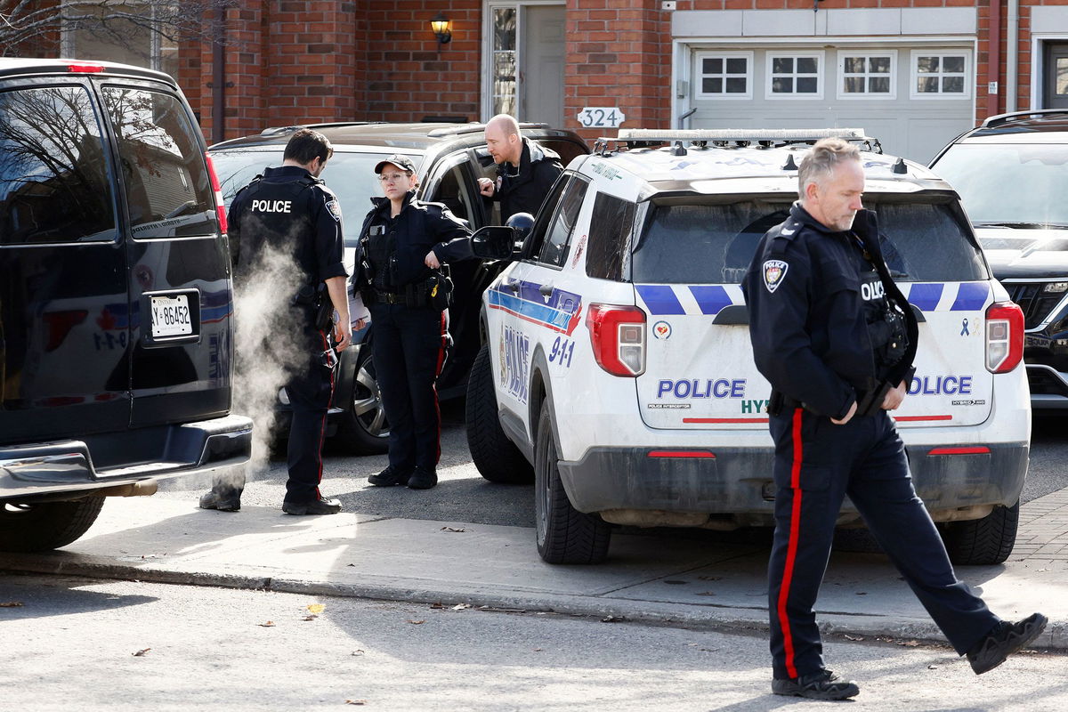 <i>Blair Gable/Reuters via CNN Newsource</i><br/>Ottawa Police Service officers surround a home after four children and two adults were found dead in the Ottawa suburb of Canada.