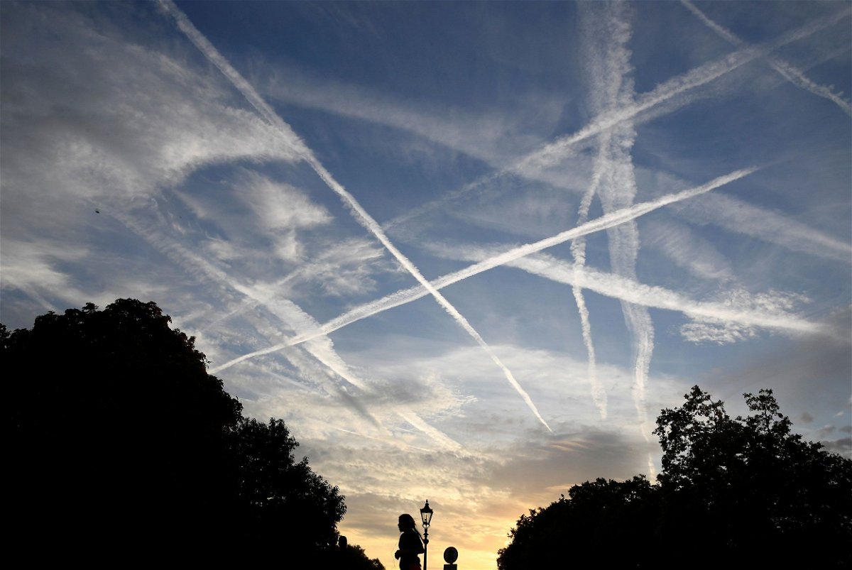 <i>Toby Melville/Reuters via CNN Newsource</i><br/>Aircraft contrails in the sky at dawn in London. Many people believe these contrails are actually dangerous or being used for conspicuous purposes.