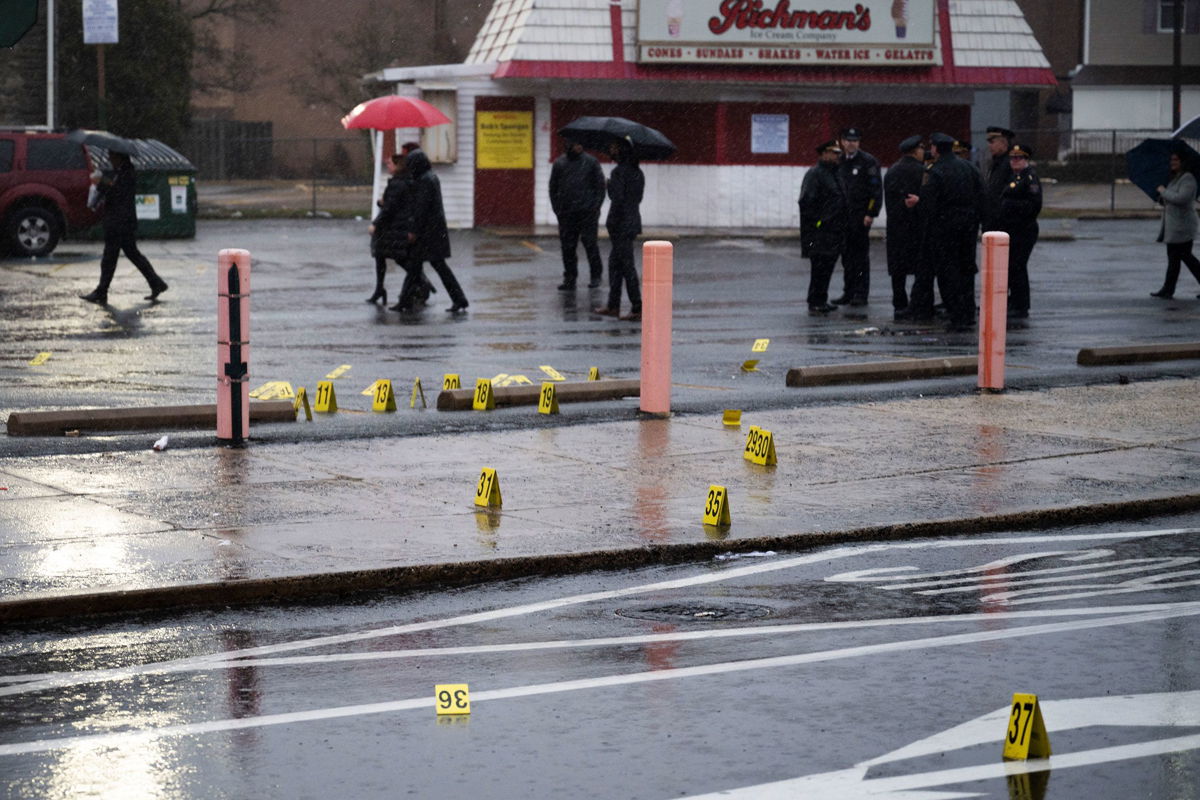 <i>Joe Lamberti/AP via CNN Newsource</i><br/>Evidence markers are seen following a shooting in Northeast Philadelphia on March 6. Two 18-year-olds have been arrested for allegedly unleashing a hail of gunfire at high school students waiting at a bus stop in Northeast Philadelphia