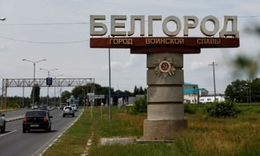 Cars drive past a sign displaying the city name in Belgorod