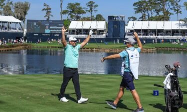 Ryan Fox of New Zealand celebrates after holing his tee shot on the 17th hole for a hole in one as his caddie Dean Smith reacts during the first round of THE PLAYERS Championship on the Stadium Course at TPC Sawgrass on March 14