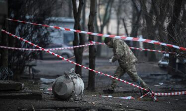 A bomb squad member works next to a part of a missile after a Russian missile attack in Kyiv.