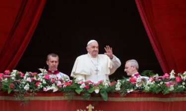 Pope Francis waves from a balcony on Easter Sunday. Francis called for an "immediate ceasefire" during his address.