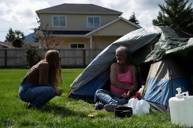 Cassy Leach, a nurse, who leads a group of volunteers who provide food, medical care and other basic goods to the hundreds of homeless people living in the parks, talks to Kimberly Marie, who is homeless and camping in Fruitdale Park on Thursday, March 21, 2024, in Grants Pass, Ore.