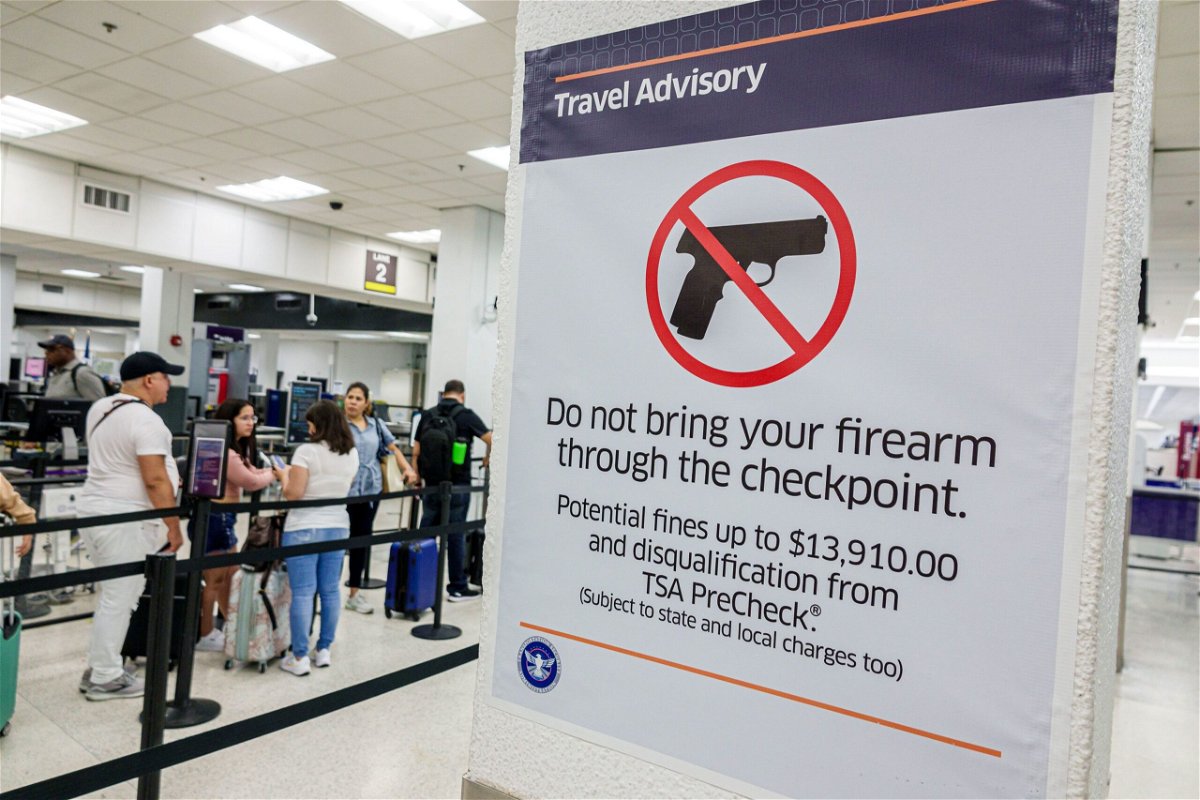 <i>Jeffrey Greenberg/UCG/Universal Images Group/Getty Images via CNN Newsource</i><br/>A sign at Miami International Airport's security screening lays out the consequences of trying to bring a firearm through the checkpoint.
