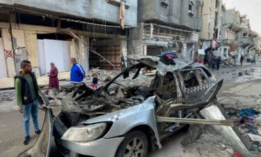 People look at the car in which three sons of Hamas leader Ismail Haniyeh were killed in an Israeli air strike near Al Shati