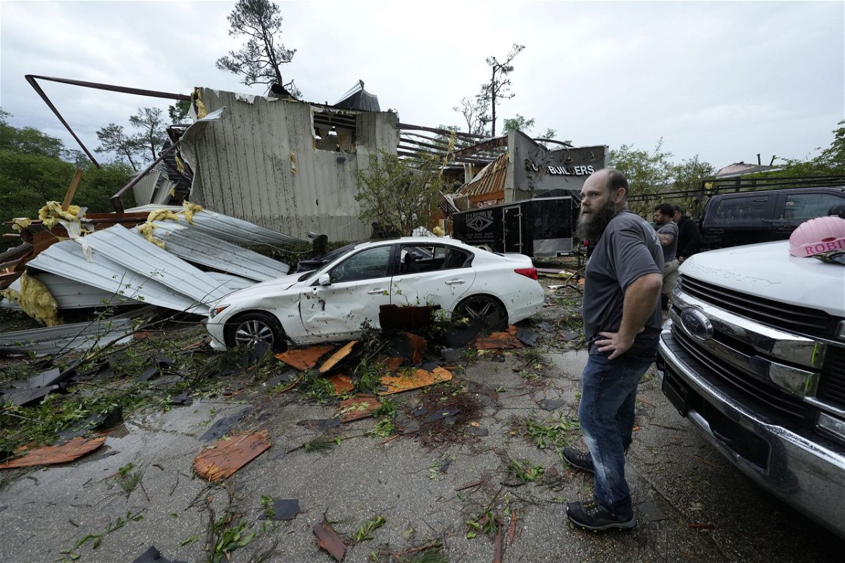 <i>Gerald Herbert/AP via CNN Newsource</i><br/>A firefighter clears debris left in the aftermath of storms in Slidell