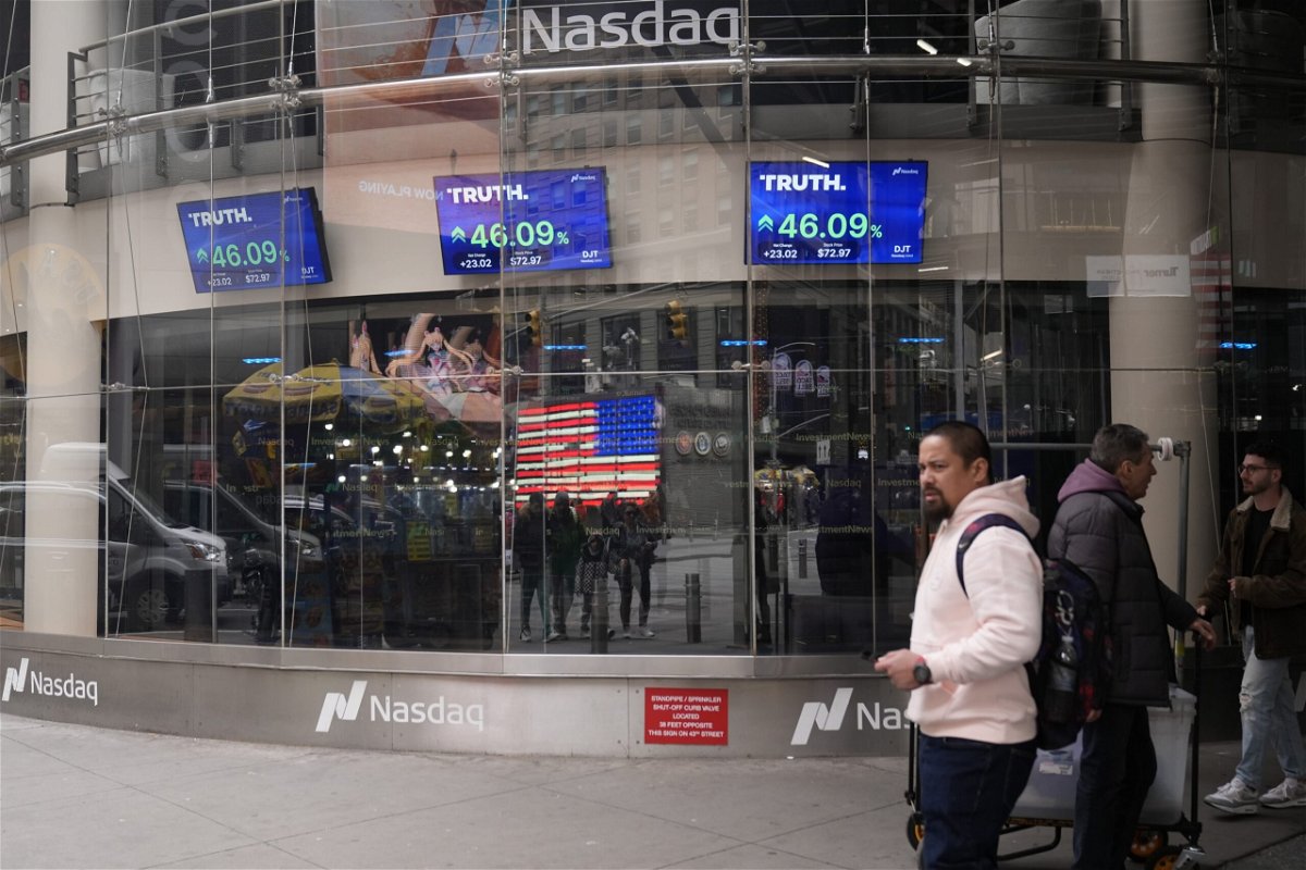 <i>Frank Franklin II/AP via CNN Newsource</i><br/>Pedestrians walk past the Nasdaq building on March 26 in New York. Anyone who bought Trump Media at the closing high of $66.22 on March 27 has now lost more than half of their money.