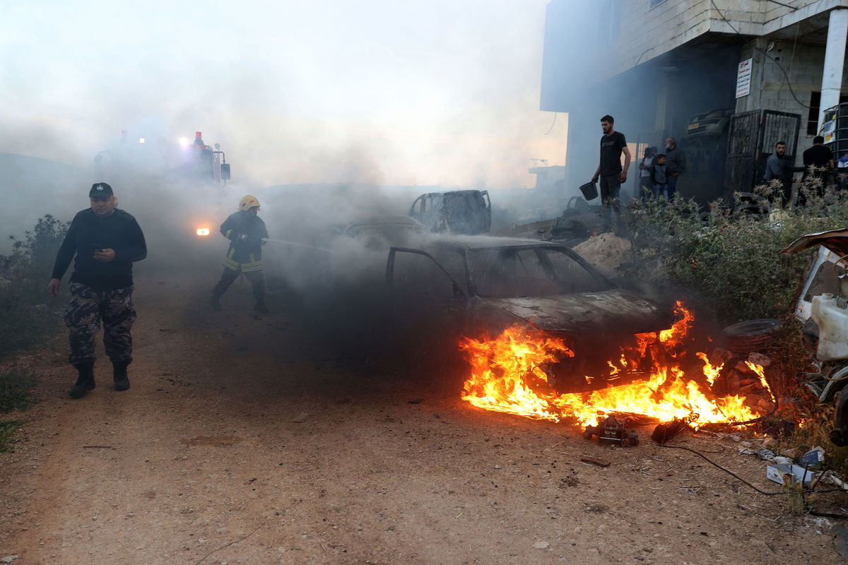 <i>Reuters via CNN Newsource</i><br/>Israeli settlers wearing headscarves are seen near billowing smoke.