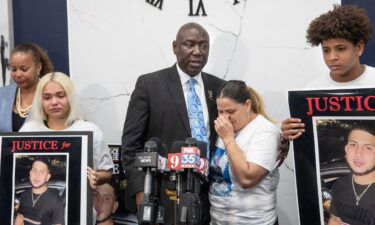 Attorney Ben Crump holds Yaneri Diaz Rodriguez as she cries during a news conference about the killing of her son