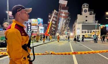 A rescue worker stands near the cordoned off site in the aftermath of an earthquake in Hualien