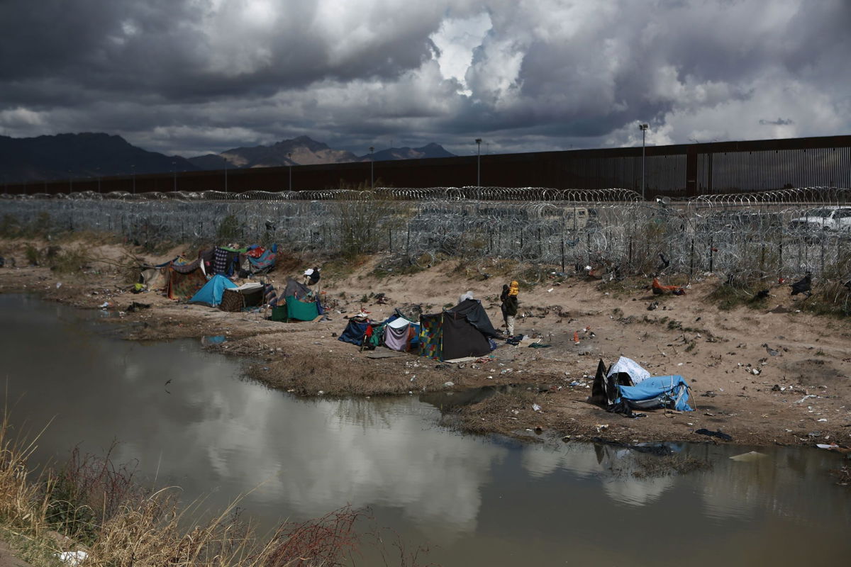<i>Christian Torres/Anadolu/Getty Images via CNN Newsource</i><br/>Migrants build makeshift tents with blankets to protect themselves from the cold as an American helicopter guards the border in Ciudad Juarez