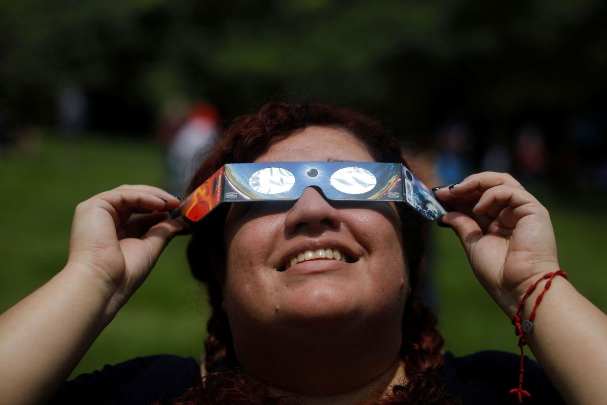 <i>Jose Cabezas/Reuters via CNN Newsource</i><br/>A woman uses eclipse glasses to observe an annular solar eclipse at the Bicentenario Park in Antiguo Cuscatlan