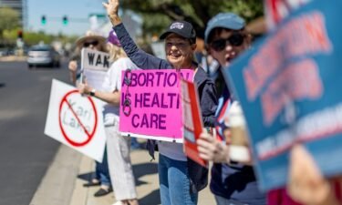 Arizona residents rally for abortion rights on a street corner on the heels of the Arizona's Supreme Court decision enacting an 1864 law banning abortion on April 16