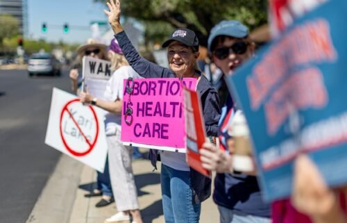 Arizona residents rally for abortion rights on a street corner on the heels of the Arizona's Supreme Court decision enacting an 1864 law banning abortion on April 16