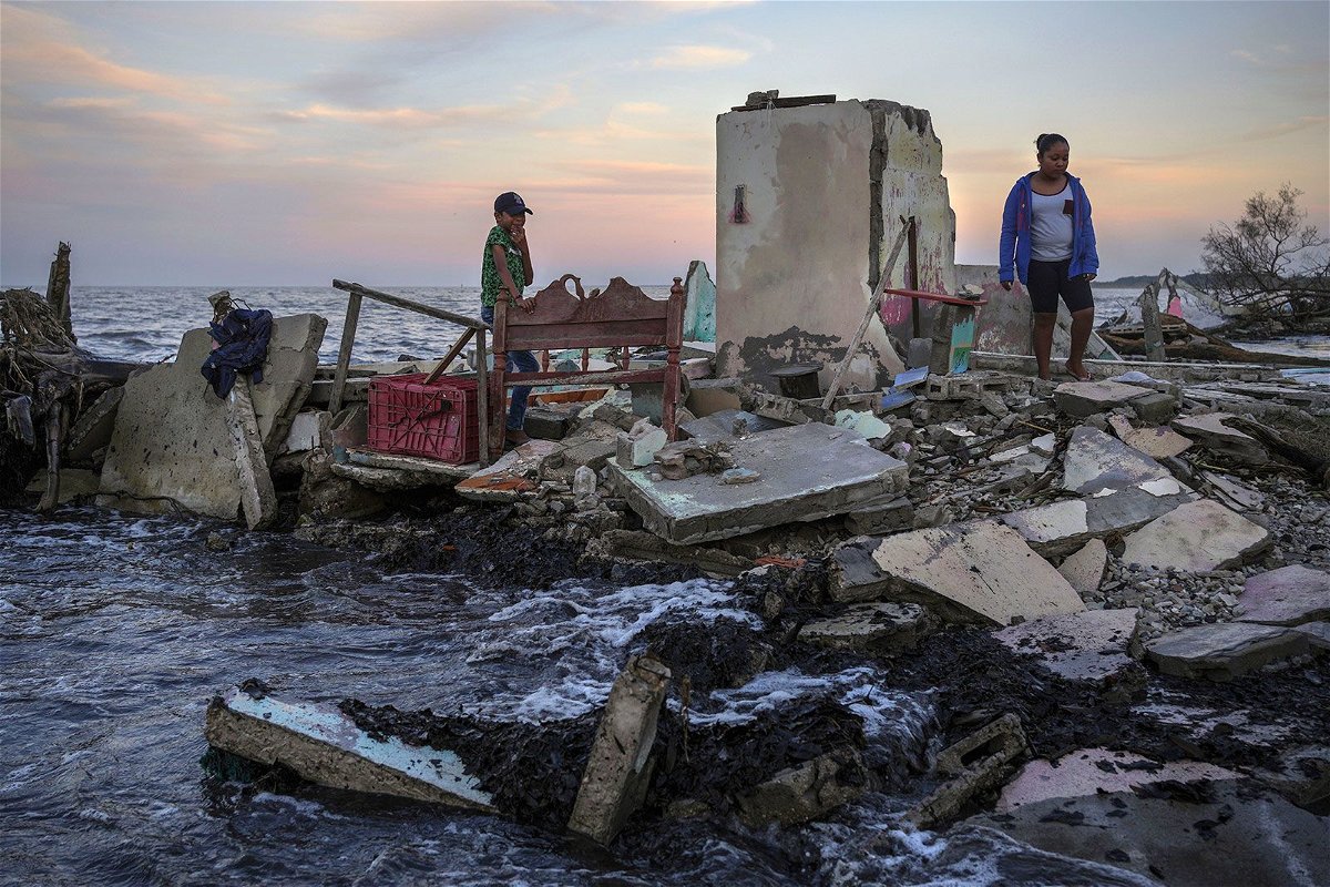 <i>Felix Marquez/AP/File via CNN Newsource</i><br/>Yahir Mayoral and Emily Camacho walk amid the rubble of their grandmother's home