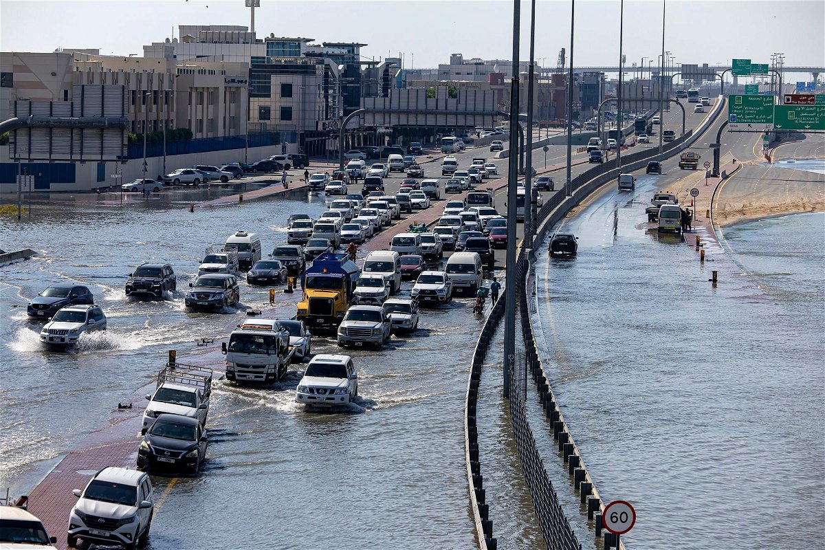 Vehicles attempt to navigate standing floodwater in Dubai