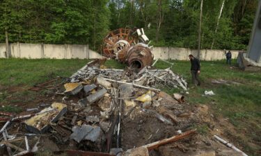 People walk next to a part of a television tower partially destroyed by a Russian missile strike in Kharkiv