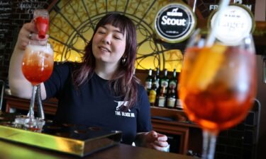 An employee at The Black Dog pub is pictured making an  'Aperol Spritz (Taylor's Version)' cocktail.