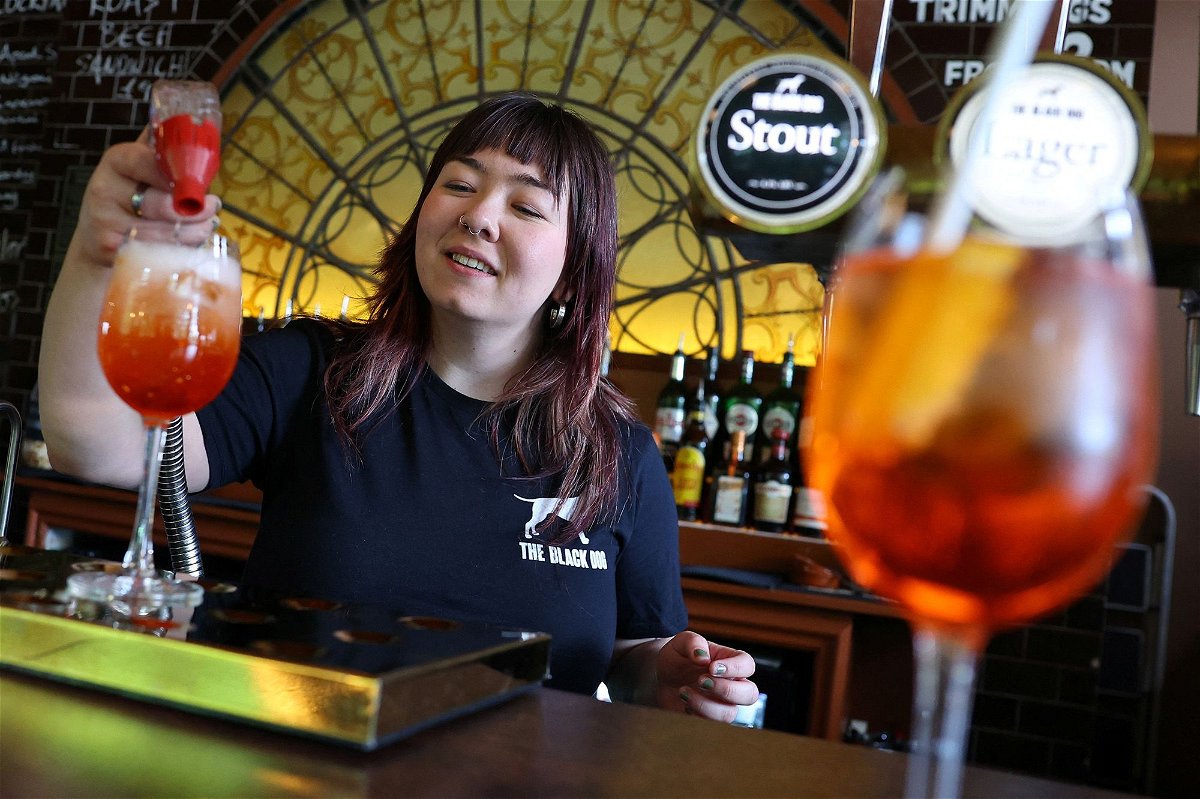 <i>Toby Melville/Reuters via CNN Newsource</i><br/>An employee at The Black Dog pub is pictured making an  'Aperol Spritz (Taylor's Version)' cocktail.